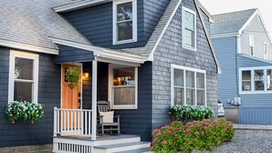 A two-story house with a porch, a front door, and a small seating area. - Seaside HOT TUB Oasis - Only STEPS from the Beach!! (Scarborough)