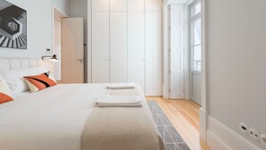 Un dormitorio moderno con una cama grande, un armario y vistas al exterior.