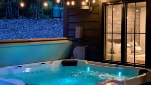Ein Whirlpool mit Blick auf ein Schlafzimmer durch eine Glastür.