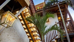 A staircase with illuminated steps, a hanging lantern, and a palm tree.