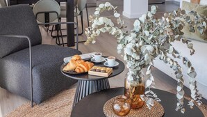 A cozy seating area with a round table, a vase with eucalyptus branches, and a plate of croissants and pastries. - Apartamento Balcón Rincón de la Victoria by Ruralidays (Málaga)