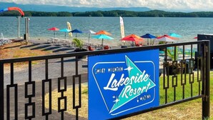 Une enseigne indiquant l’emplacement de Lakeside Resort, avec en arrière-plan une vue sur un lac et des montagnes.