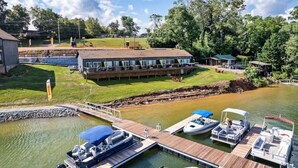 Une propriété située au bord d’un lac, dotée d’un quai, de bateaux et d’un bâtiment comprenant plusieurs pièces.