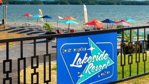 A lakeside resort sign with a view of the lake and mountains in the background.