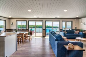 A spacious living area with a large sofa, a dining table, and a kitchen area. - The Lodge @Smoky MTN Lakeside (Dandridge)