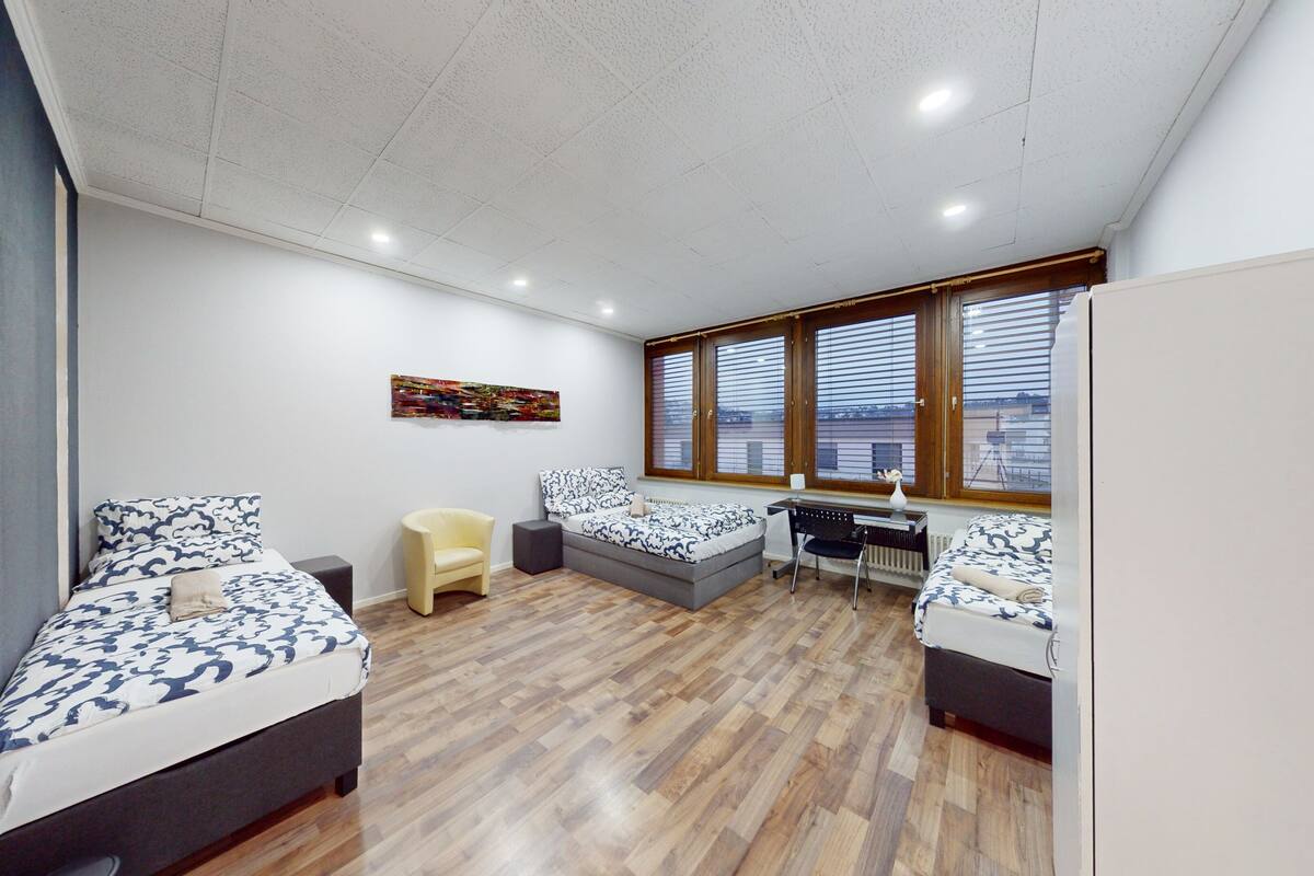 Une chambre avec deux lits, un bureau et une chaise.