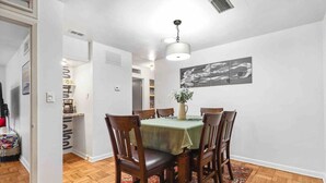 A dining area with a round table, chairs, a green tablecloth, and a vase with flowers. - Quiet & Close to hospitals, UF and more (Gainesville)