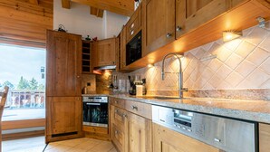 A modern kitchen with wooden cabinets, stainless steel appliances, and a tiled backsplash.
