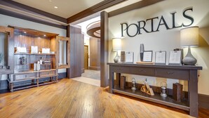 A reception area with a wooden floor, a reception desk with a sign reading "PORTALS," and a wall-mounted lamp. - Pet-Friendly Cle Elum Condo - Hike, Ski & Relax! (Cle Elum)