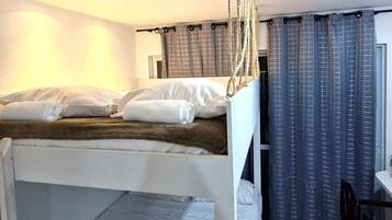 Et hotelværelse med køjesenge, et skrivebord og en stol.