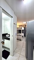 Habitación de hotel moderna con cocina, armario empotrado y balcón con vistas.