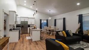 A modern apartment with a kitchen, dining area, and living room.
