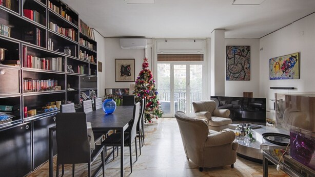 A spacious living room with a large bookshelf, a dining area, and a cozy seating arrangement. - Trastevere Bright Enchanting Apartment (Roma)