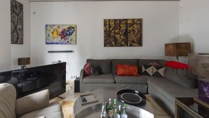 A modern living room with a sofa, coffee table, and artwork on the walls. - Trastevere Bright Enchanting Apartment (Roma)