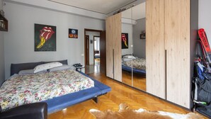 A bedroom with a bed, a mirror, and a wardrobe. - Trastevere Bright Enchanting Apartment (Roma)