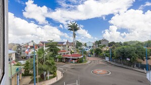 Vista de una calle con edificios, palmeras y una glorieta.