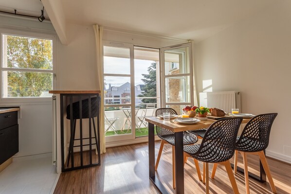 Eine moderne Küche mit Essbereich, großen Fenstern und Blick ins Freie.