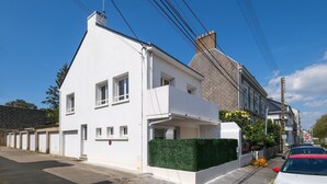 A modern two-story building with a white facade, a green hedge, and a clear blue sky. - La Balnéaire - Vue mer, à 50 m de la plage et de la baie (Saint-Nazaire)