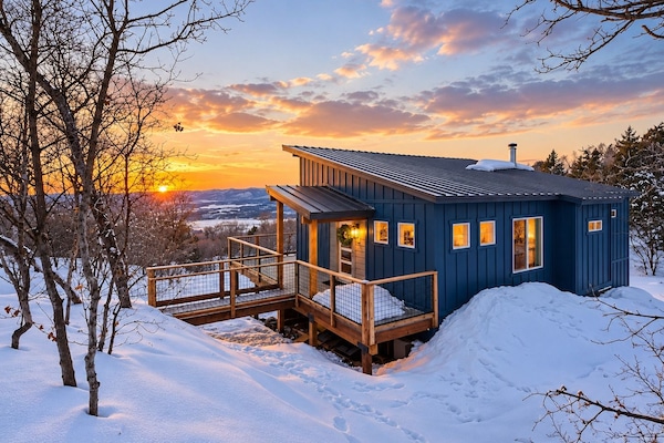 Hummingbird Hideaway cabin and wraparound deck glowing at snowy sunset