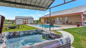 A hot tub area with a covered patio, a pool, and outdoor furniture. - Countryside Texas Sanctuary Enjoy Sunrises & Sunsets, Grill, Firepit & Longhorns (Pattison)