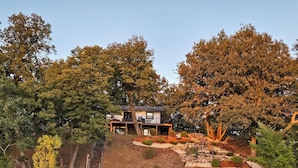 A lakeside house with a deck and stairs leading to a dock.