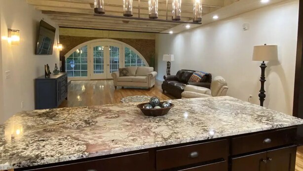 A spacious living area with a large island counter, a fireplace, and a cozy seating arrangement.