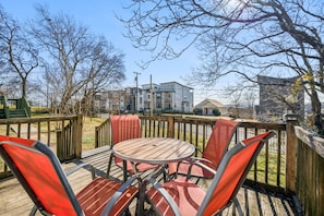 A wooden deck with a round table and four chairs, surrounded by a wooden fence.