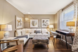 A modern living room with a sofa set, a coffee table, a desk with a chair, and artwork on the walls. - Family Friends and free parking 1mile to downtown (Nashville)