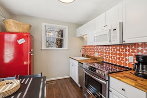 A compact kitchen with a red refrigerator, a microwave, an oven, and a coffee maker. - Family Friends and free parking 1mile to downtown (Nashville)