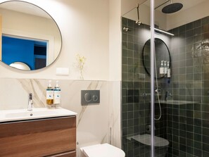 A modern bathroom with a glass-enclosed shower, a marble vanity, and a toilet. - Numa Lisbon Rato (Lisbon)