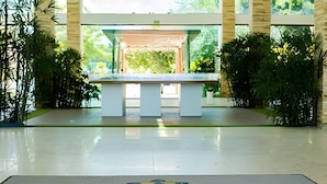 A reception area with a bench, potted plants, and a floor with 'iloa residence' text.