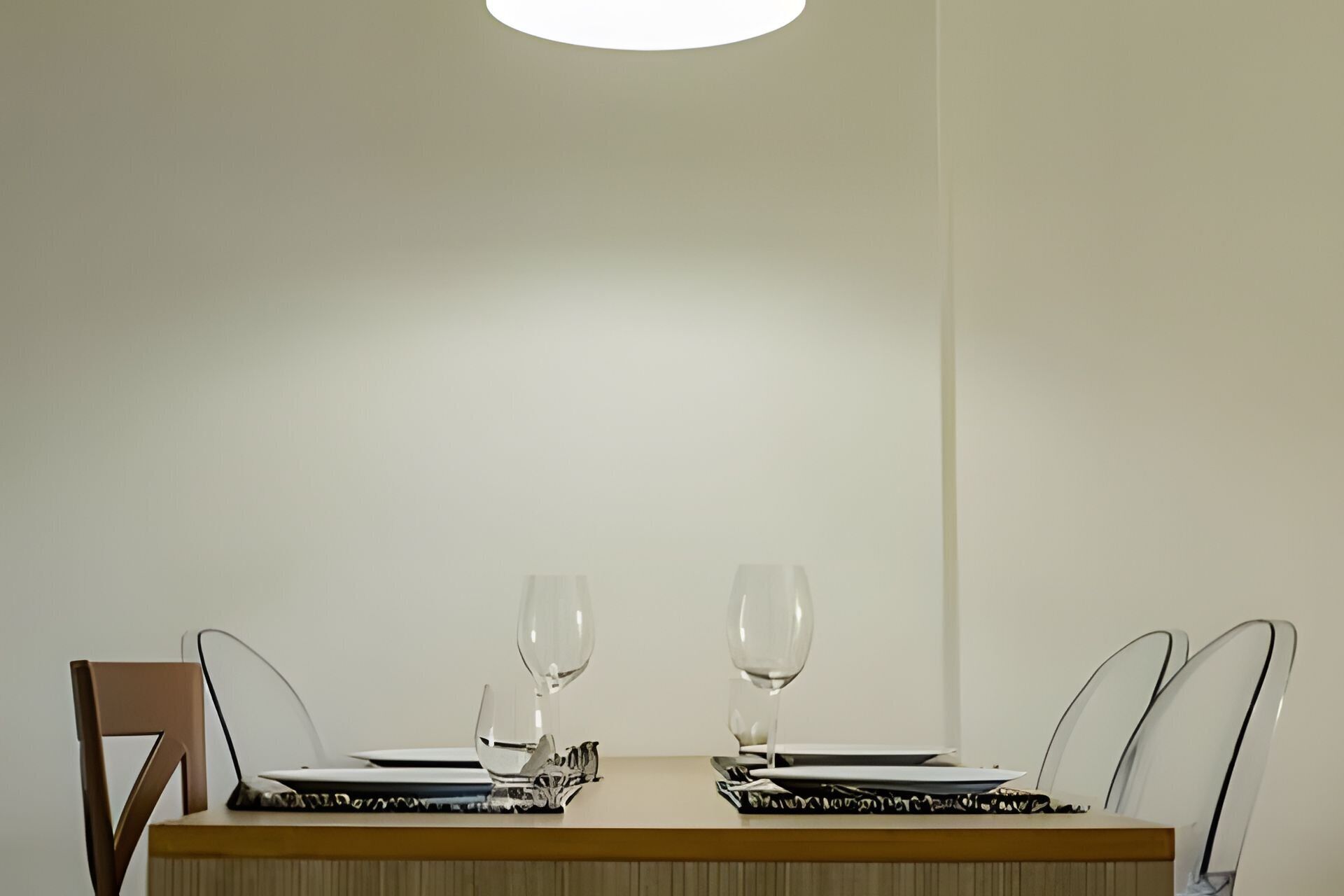 Un tavolo da pranzo con due sedie, un laptop e due bicchieri da vino.