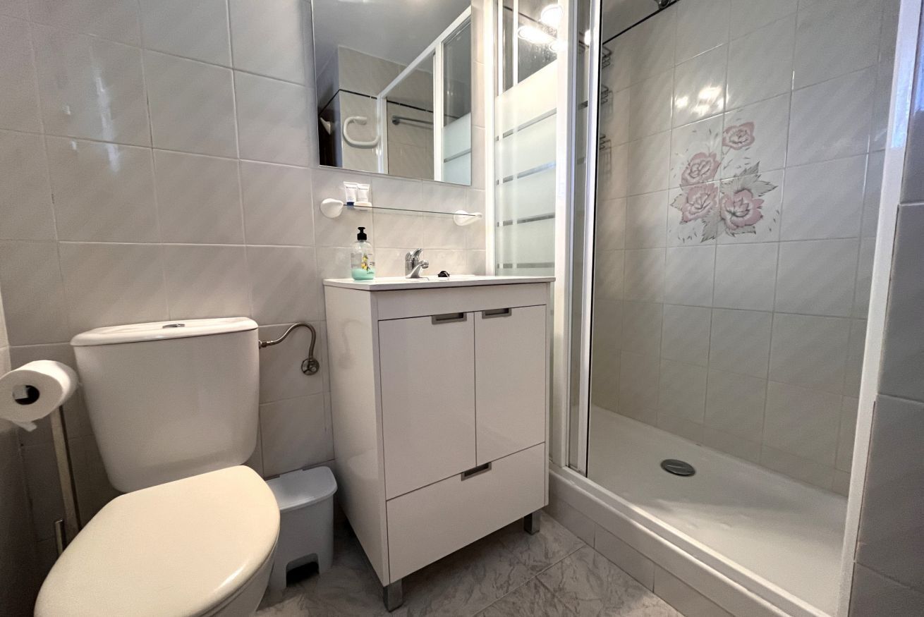A bathroom with a toilet, sink, and shower.