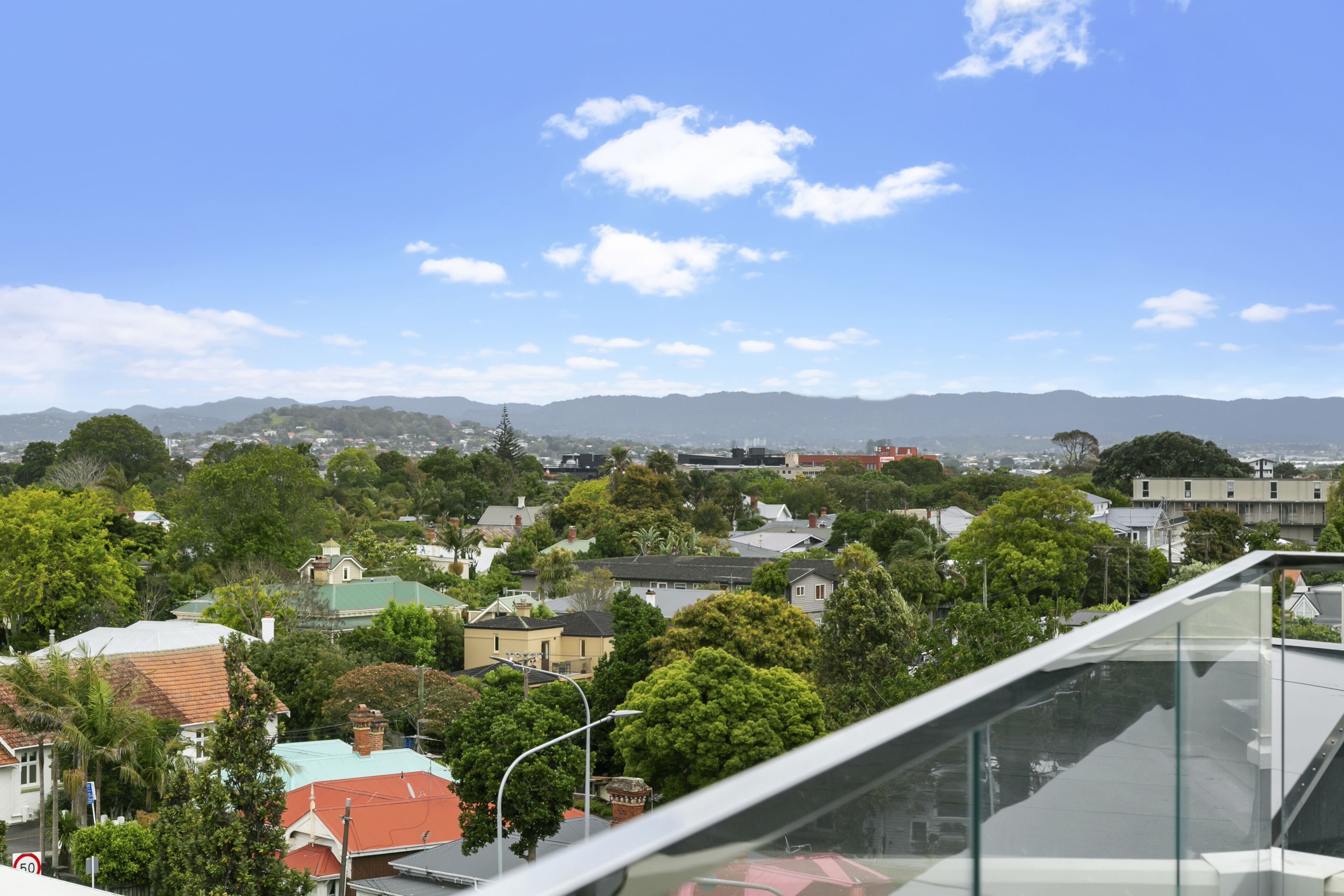 A residential area with houses, trees, and a clear sky.