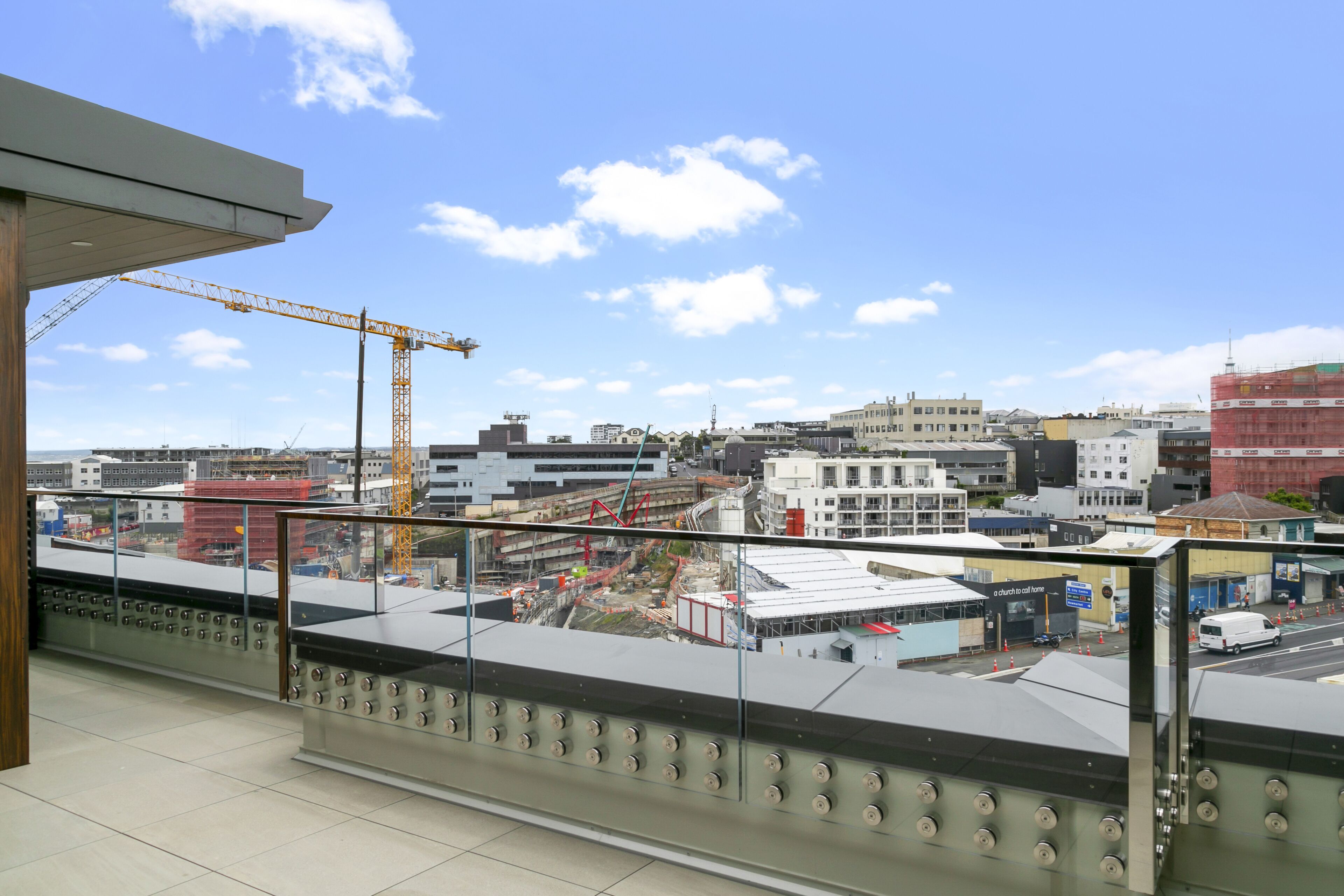 Ein Balkon mit Blick auf die Stadt, einschließlich Gebäude und einer Baustelle.