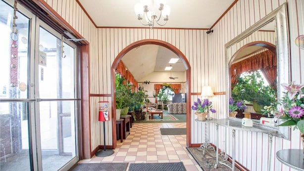 A hotel lobby with a checkered floor, wooden paneling, a reception desk, and a chandelier. - Hotel O Daylight Inn Elkhart I-90, In (Elkhart)
