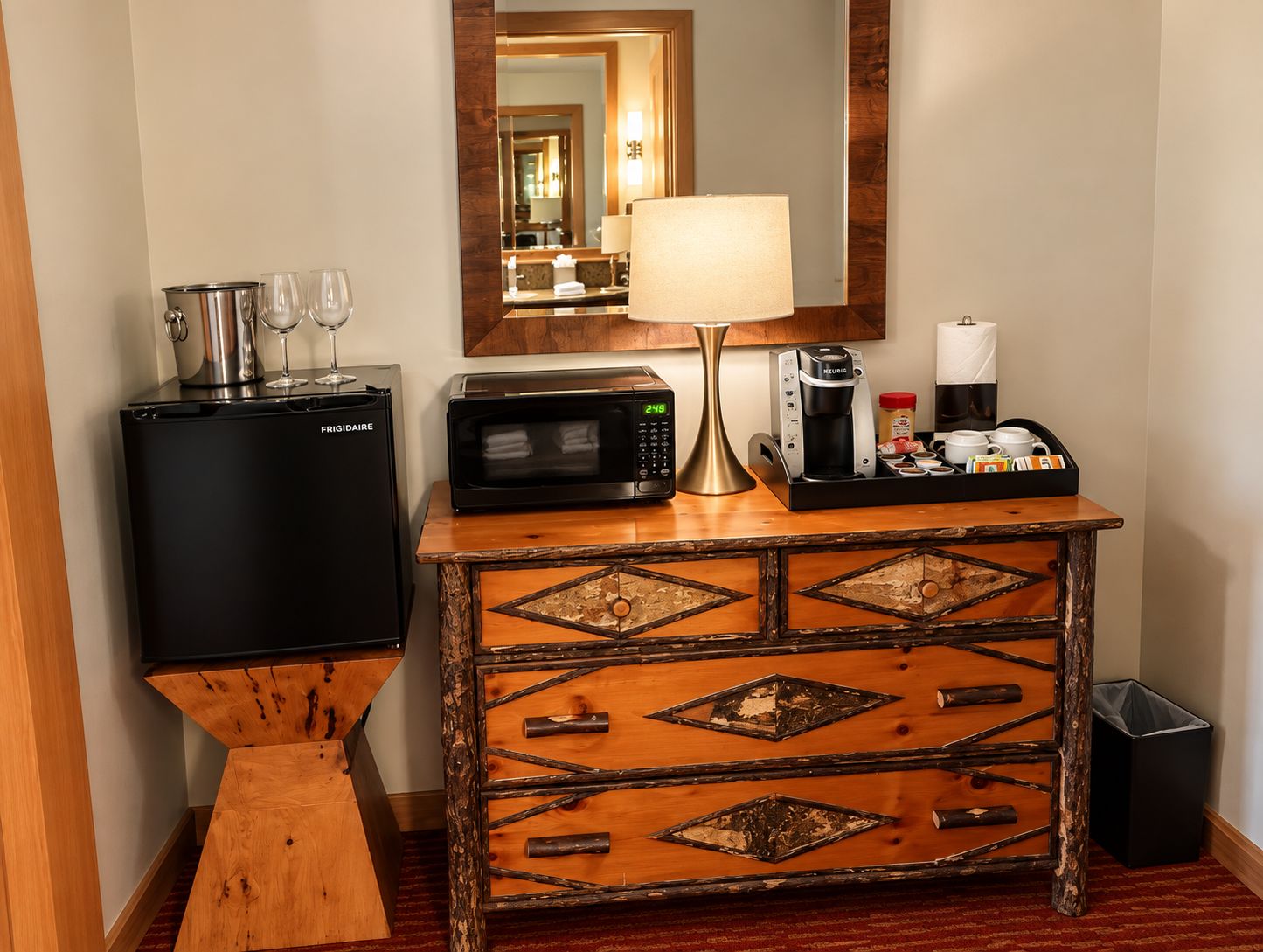 A compact kitchenette with a refrigerator, microwave, coffee maker, and a small sink.