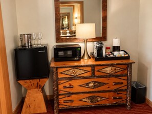 A compact kitchenette with a refrigerator, microwave, coffee maker, and a small sink.