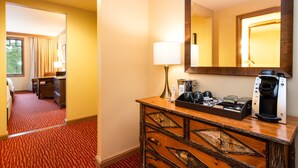 Une chambre d’hôtel avec une commode en bois, une machine à café et un miroir.