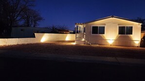 A small, single-story house with a porch and a covered staircase. - Red Mesa house  (Page)