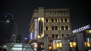A hotel with a 'Welcome' sign, a 'Burger Palace' sign, and a 'Hotel DomA' sign. - Hotel Doma Myeongdong  (Seoul)