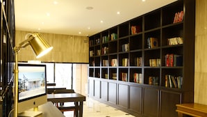 A modern library with a large bookshelf, a desk with a computer, and a lamp. - Hotel Doma Myeongdong  (Seoul)