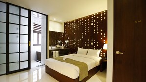 A modern hotel room with a large bed, a wooden headboard with circular patterns, a separate bathroom with a sliding door, and a visible room number 610. - Hotel Doma Myeongdong  (Seoul)