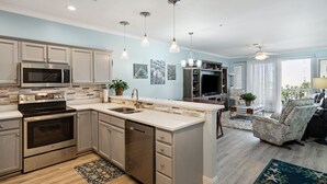 A modern kitchen with stainless steel appliances, a central island, and pendant lighting.
