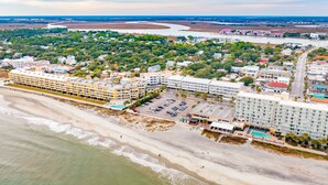 A coastal hotel with multiple buildings, a beach, and a marina.
