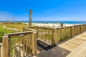 A wooden deck leading to a beach with a sign warning against walking on the sand before swimming. - Bluewater 104 | Gulf Front Garden Condo | Indoor, Outdoor & Kiddie Pool | My Beach Getaways (Orange Beach)