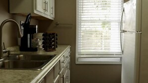 A kitchen with a sink, cabinets, a window with blinds, and a refrigerator. - Spacious 6-Bedroom Retreat in Central Lafayette, Perfect for Groups & Families (Lafayette)