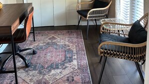 A room with a wooden dining table, two wicker chairs, a patterned rug, a large white closet, and a window with blinds. - Spacious 6-Bedroom Retreat in Central Lafayette, Perfect for Groups & Families (Lafayette)