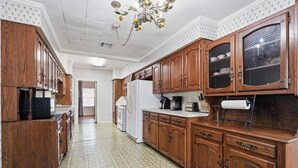 A kitchen with wooden cabinets, a white refrigerator, and a patterned floor. - Home Away From Home-4 BR Lafayette Stay in the Heart of Town (Lafayette)