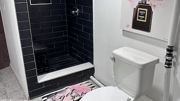 Een douche, handdoeken, zeep, toiletpapier